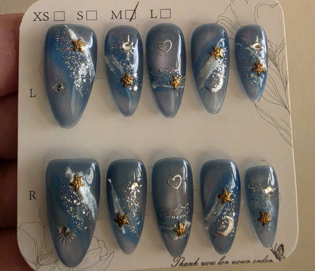 Cat's eye Celestial Blue Press-On Nails [M size] (Category: Hands & Nails) located in Cavite. Submitted by phoibee (Listing ID 1468783108, Image 2). Description: - Style: Celestial blue press-on nails with gold stars, silver moons, tiny hearts, glitter swirls, and rhinestones - only worn to fit the thumb. never used. - Size: Medium.