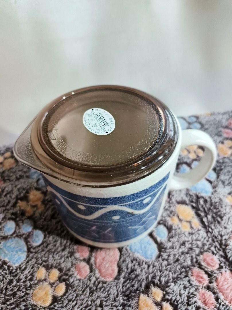 Ceramic Mug with Lid Blue Pattern (Category: Coffee & Tea Tableware) located in San Leonardo. Submitted by burgossanleonardo.12345 (Listing ID 1468766228, Image 3). Description: - Type: Ceramic mug with translucent brown lid - Design: Stylish blue pattern around the body - Dimensions: ~11 cm height, ~10 cm top diameter - Features: Sturdy side handle, clean surface overall - Condition: Excellent, ready for use.