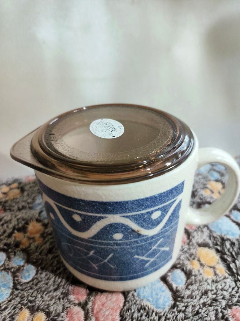 Ceramic Mug with Lid Blue Pattern (Category: Coffee & Tea Tableware) located in San Leonardo. Submitted by burgossanleonardo.12345 (Listing ID 1468766228, Image 2). Description: - Type: Ceramic mug with translucent brown lid - Design: Stylish blue pattern around the body - Dimensions: ~11 cm height, ~10 cm top diameter - Features: Sturdy side handle, clean surface overall - Condition: Excellent, ready for use.