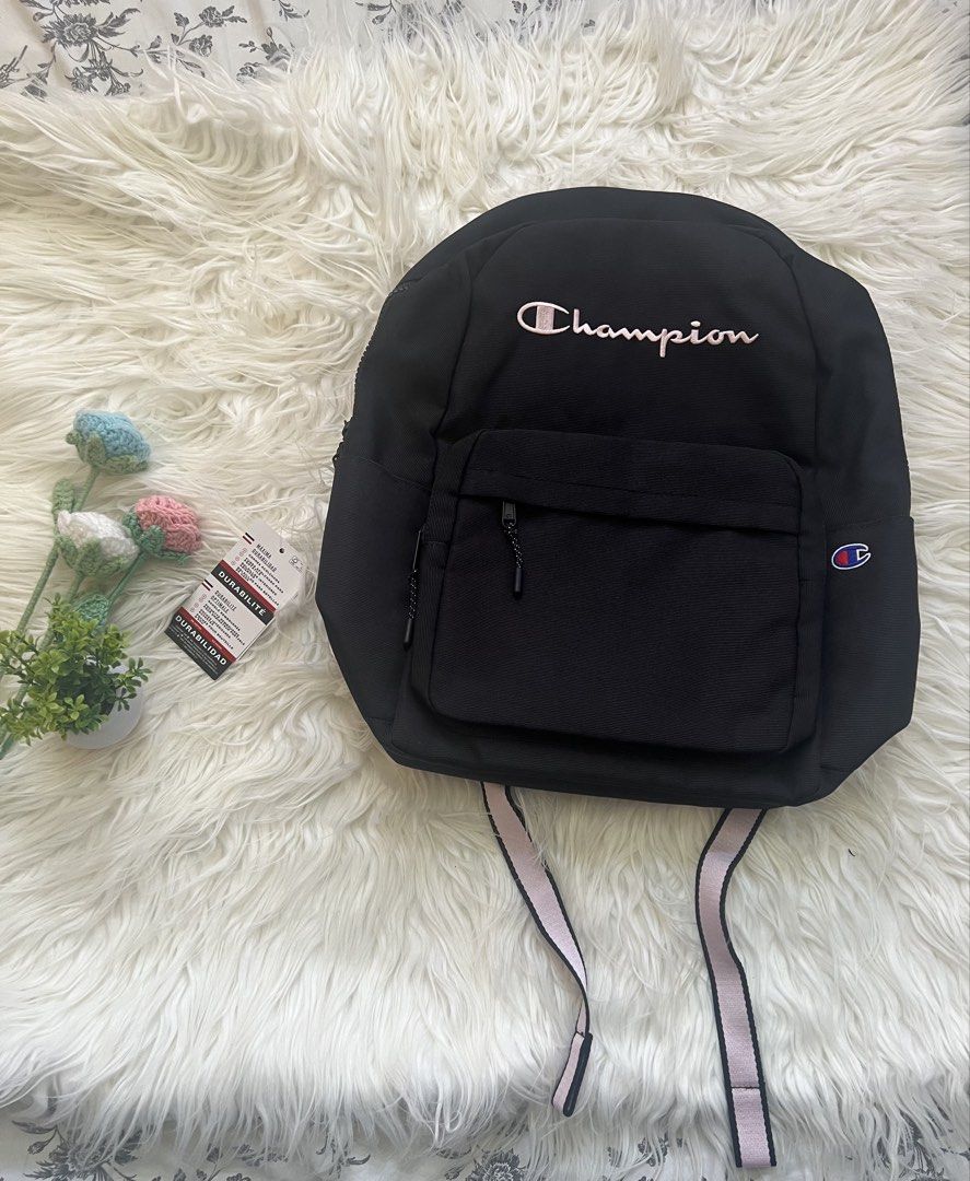 Champion Black Backpack With Pink Straps (Category: Backpacks) located in Lapu Lapu. Submitted by rubysbagel38206 (Listing ID 1468811469, Image 1). Description: - Brand new with tags still attached - Color: Black with light pink straps and embroidered pink Champion logo - Spacious main compartment for school, work, or travel - Front zippered pocket with iconic 'C' patch - Comfortable adjustable straps for everyday use.
