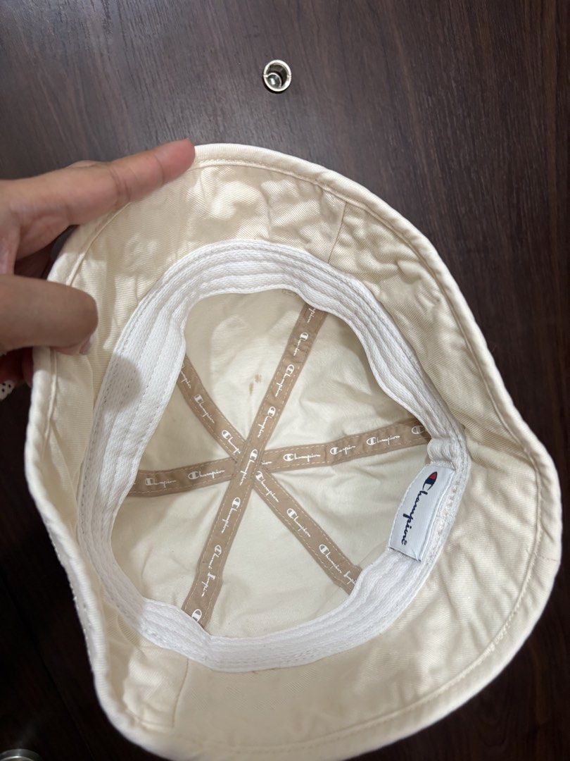 Champion Cream Bucket Hat (Category: Caps & Hats) located in Mandaluyong City. Submitted by mclldmrl (Listing ID 1468742906, Image 3). Description: - Brand: Champion - Color: Cream - Style: Classic canvas bucket hat with stitched brim - Details: Black Champion logo patch on front, embroidered C logo on back - Comfort: Interior sweatband and branded inner taping.