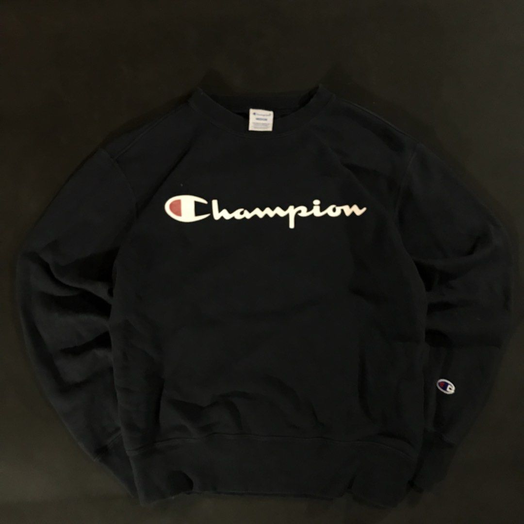Champion Script Logo Crewneck Sweatshirt (Category: Coats, Jackets and Outerwear) located in Manila. Submitted by a_aron.f6e3a7 (Listing ID 1468786614, Image 2). Description: Size: Medium (M) Color rate: 9/10 (Navy Blue/Black with White & Red Script Logo) Condition: Excellent Issues: Visible wrinkles and creases from storage; no visible major holes or tears .