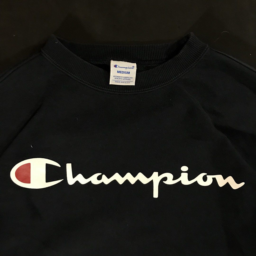 Champion Script Logo Crewneck Sweatshirt (Category: Coats, Jackets and Outerwear) located in Manila. Submitted by a_aron.f6e3a7 (Listing ID 1468786614, Image 3). Description: Size: Medium (M) Color rate: 9/10 (Navy Blue/Black with White & Red Script Logo) Condition: Excellent Issues: Visible wrinkles and creases from storage; no visible major holes or tears .