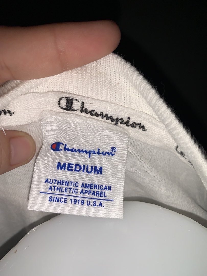 Champion White Pocket T-Shirt Medium (Category: Tshirts & Polo Shirts ) located in Cardona. Submitted by rmlyn1998 (Listing ID 1468714130, Image 2). Description: - Authentic Champion t-shirt in Men's Size Medium - Classic white color with bold blue and red script logo across the chest - Convenient chest pocket on the right side - Signature embroidered 'C' logo on the left sleeve - Comfortable crew neckline and short sleeves - Official athletic ap