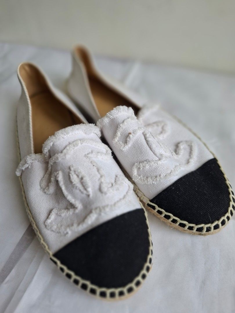 Chanel White Canvas Black Cap Toe Espadrilles Size 38 (Category: Sneakers & Footwear) located in Muntinlupa City. Submitted by iaramos (Listing ID 1468745282, Image 2). Description: - Brand: Chanel - Style: Slip-on espadrilles / flats - Color: White canvas with black cap toes - Details: Iconic frayed CC logos on top - Size: 38 (marked on soles) - Origin: Made in Spain - Soles: Rubber with diamond pattern (light wear from normal walking) - Insoles