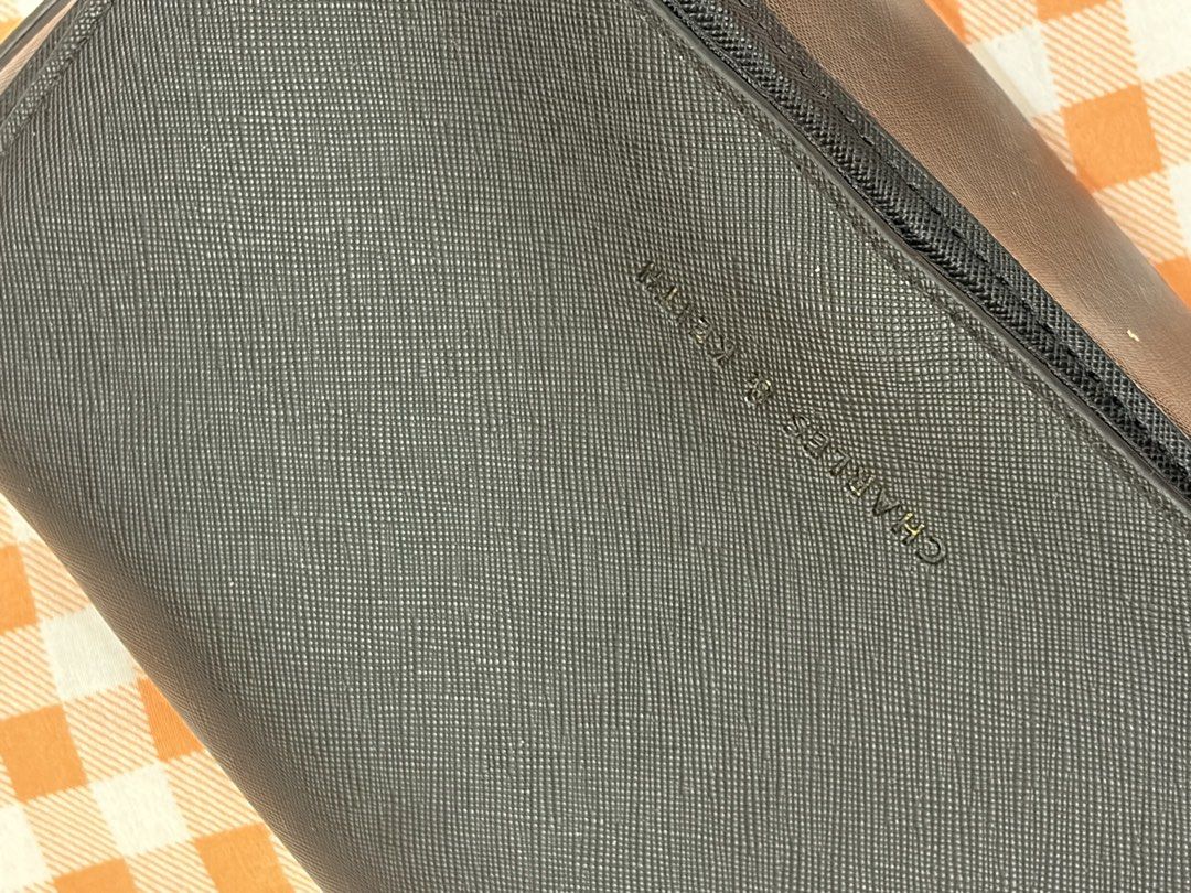 Charles & Keith Black Crossbody Bag (Category: Cross-body Bags) located in Manila. Submitted by jdace (Listing ID 1468846494, Image 2). Description: - Brand: Charles & Keith - Material: Textured Saffiano leather in classic black - Closure: Flap with embossed front logo - Strap: Stylish chain combined with a comfortable leather shoulder section - Interior: Clean black lining - Size: Compact, ideal for phone, keys, and daily essentials - Condition: