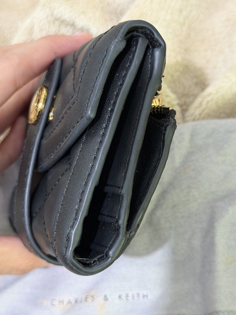 Charles & Keith Black Quilted Wallet (Category: Wallets & Card holders) located in Manila. Submitted by declutterwtmaan (Listing ID 1468753235, Image 2). Description: Black quilted wallet from Charles & Keith. Gold-tone hardware with a snap button closure. Includes multiple card slots and a zipped coin compartment on the back. Original branded dust bag included. OG SIGNS OF USAGE GOOD CONDITION.