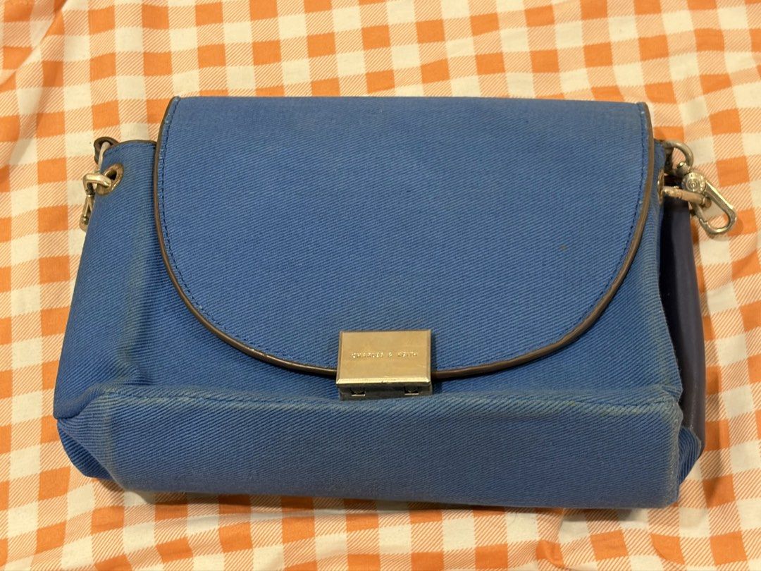Charles & Keith Blue Denim Crossbody Bag (Category: Cross-body Bags) located in Manila. Submitted by jdace (Listing ID 1468847043, Image 2). Description: - Authentic Charles & Keith shoulder bag in trendy blue denim - Features a secure flap closure with a stylish metal clasp - Contrast dark blue trim and convenient adjustable strap - Normal wear visible around edges and corners from regular use - Price is negotiable for serious buyers, PM for inq