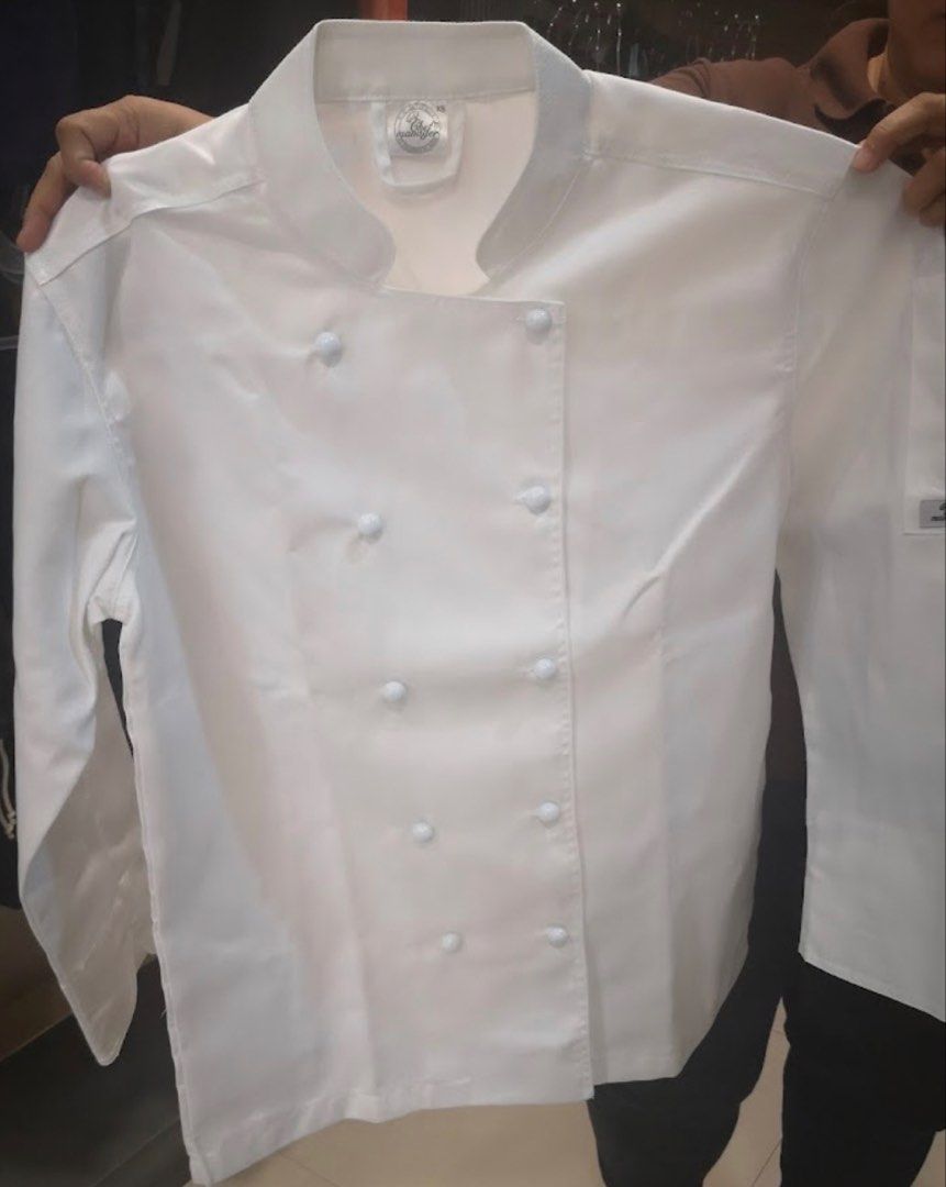 Chef Uniform (Category: Coats, Jackets and Outerwear) located in Manila. Submitted by rizalynocreto_19 (Listing ID 1468829595, Image 2). Description: - Color: White - Style: Double-breasted with traditional knot buttons - Collar: Mandarin collar - Sleeves: Long sleeves with a handy pocket on the left sleeve - Condition: Clean, crisp fabric for a professional look - Perfect for: Restaurant kitchen work, baking enthusiasts, and culinary school stud