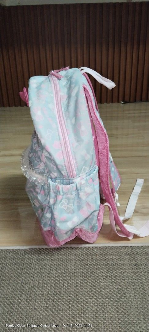 Cherish Cute Pastel Bows Girls Backpack (Category: Backpacks) located in Guiguinto. Submitted by ambershelb75728 (Listing ID 1468769511, Image 3). Description: - Design: Adorable light blue and pink backpack with an all-over ribbon and heart pattern - Special Feature: Sparkling "Cherish" glitter lettering on the front - Pockets: Front zipped pocket with a stylish ruffled trim and convenient side pockets for water bottles - Comfort: Pink padded sh