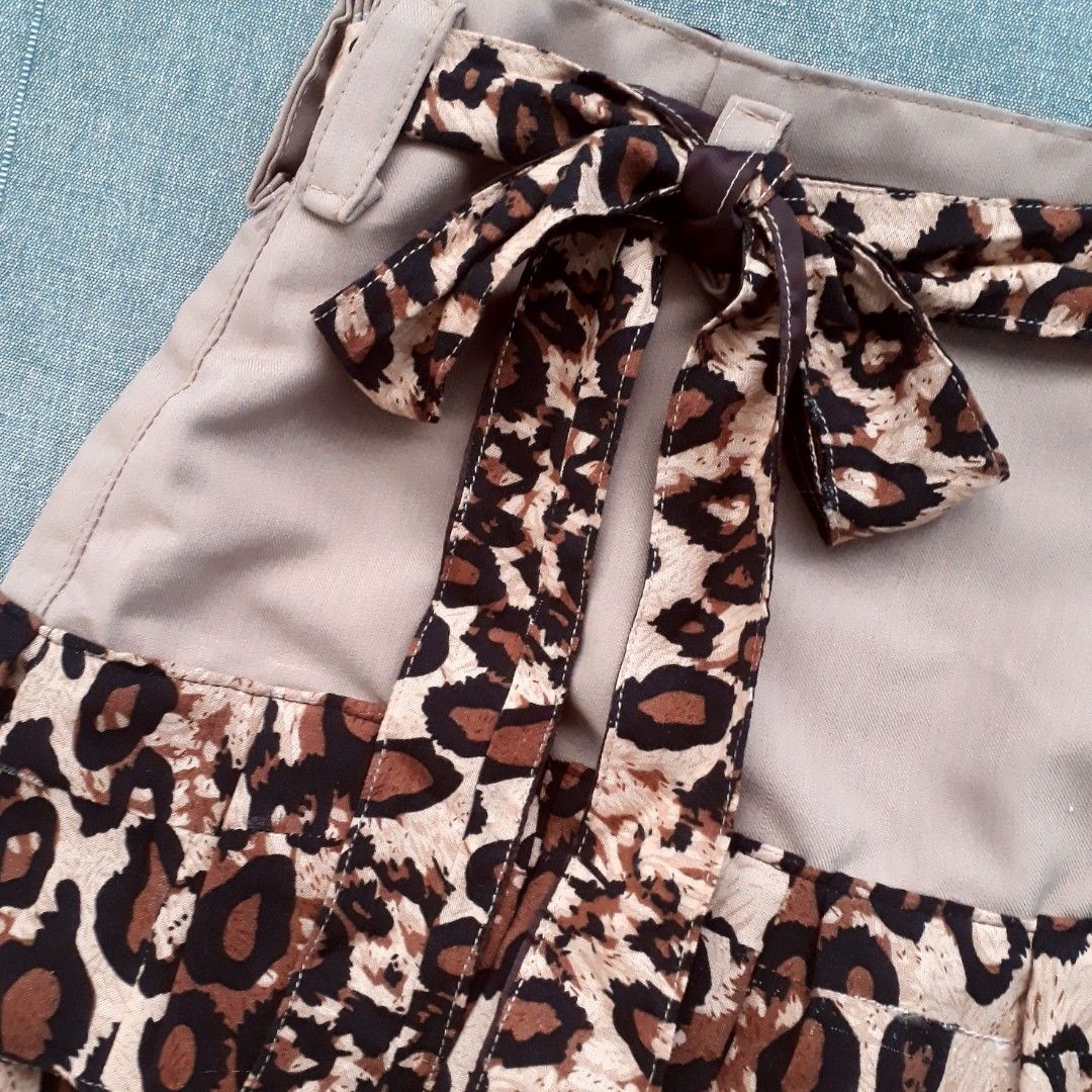 Chic Leopard Print Ruffled Mini Skirt (Category: Skirts) located in Cabanatuan. Submitted by madeby_csnstudio (Listing ID 1468727903, Image 3). Description: MEASUREMENTS: Waist: 25 inches (63.5 cm) Hips: 33 inches (83.82 cm) Length: 13.5 inches (34.29 cm) DETAILS: Channeling iconic 2000s street style, this mini skirt blends a smooth khaki tan body with bold animal print accents. The waistband is fitted with belt loops and includes a matching, lon