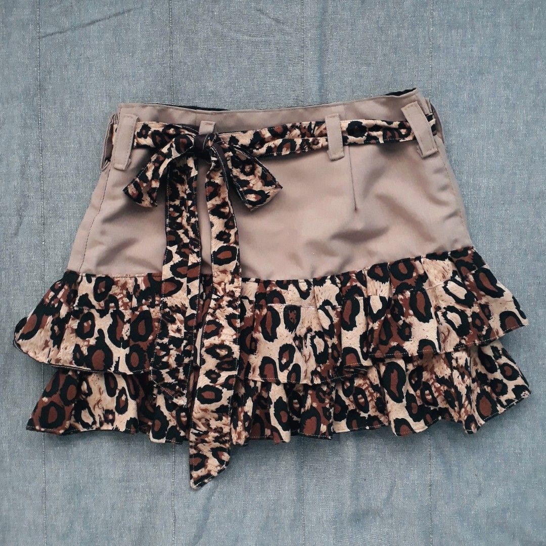Chic Leopard Print Ruffled Mini Skirt (Category: Skirts) located in Cabanatuan. Submitted by madeby_csnstudio (Listing ID 1468727903, Image 1). Description: MEASUREMENTS: Waist: 25 inches (63.5 cm) Hips: 33 inches (83.82 cm) Length: 13.5 inches (34.29 cm) DETAILS: Channeling iconic 2000s street style, this mini skirt blends a smooth khaki tan body with bold animal print accents. The waistband is fitted with belt loops and includes a matching, lon