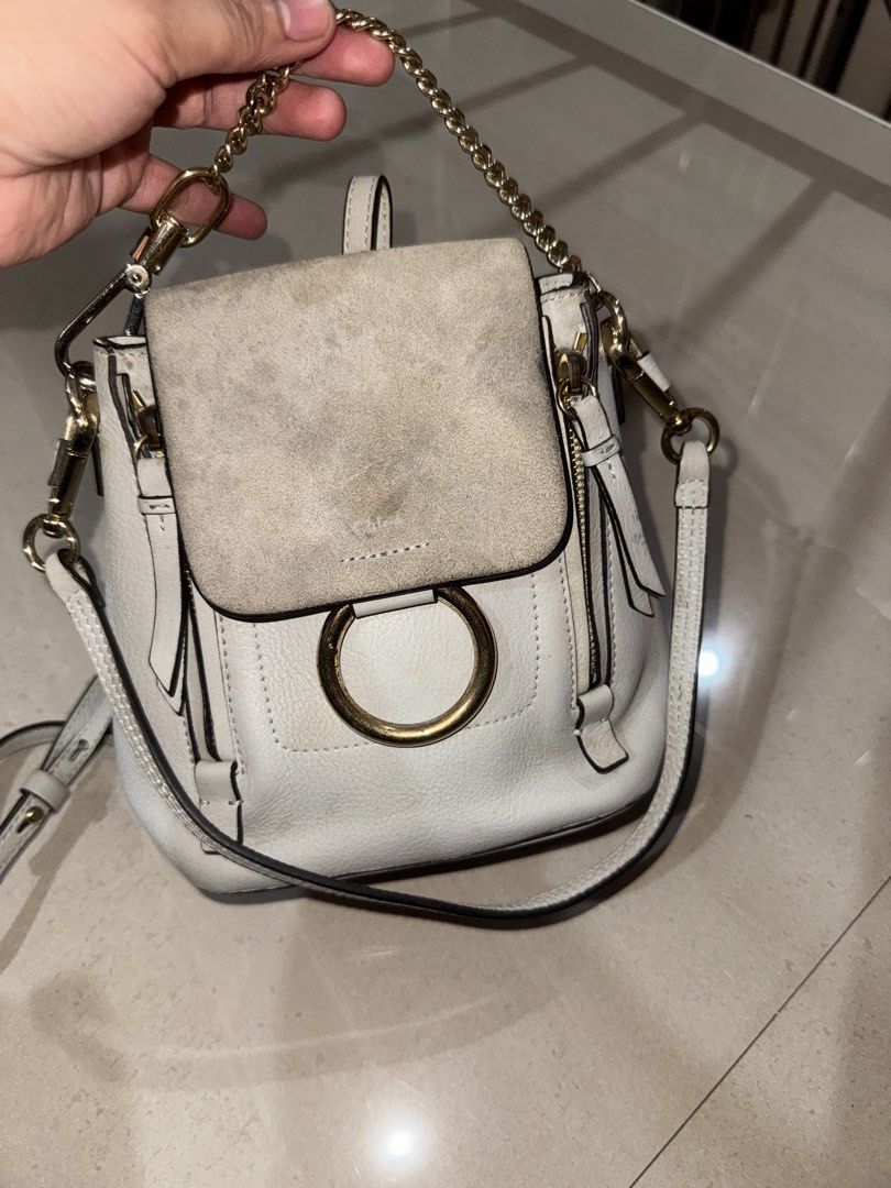 Chloé Faye Small White Leather Backpack (Category: Luxury Bags & Wallets) located in Cebu City. Submitted by latendacebu (Listing ID 1468773325, Image 1). Description: - Authentic Chloé white leather and suede convertible backpack - Features signature ring loop hardware and elegant gold-tone chain handle - Versatile design: wear as a backpack or convert into a shoulder bag - Condition: Visible discoloration and dirt marks on the suede flap, leath