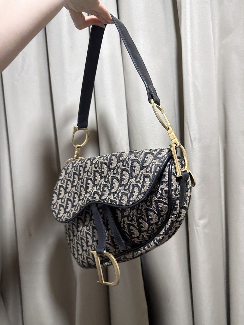 Christian Dior Oblique Saddle Bag (Category: Luxury Bags & Wallets) located in Abucay. Submitted by fastlion.584bdf (Listing ID 1468892662, Image 2). Description: - Brand: Christian Dior - Style: Iconic Saddle Bag - Material: Classic blue oblique canvas with black leather trim - Hardware: Aged gold-tone with signature D stirrup clasp and CD strap rings - Closure: Top zip closure - Interior: Fabric-lined with enough space for daily essentials - Mo