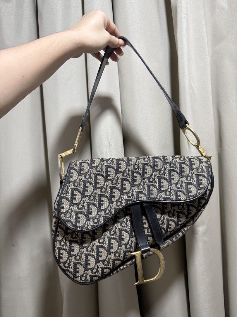 Christian Dior Oblique Saddle Bag (Category: Luxury Bags & Wallets) located in Abucay. Submitted by fastlion.584bdf (Listing ID 1468892662, Image 1). Description: - Brand: Christian Dior - Style: Iconic Saddle Bag - Material: Classic blue oblique canvas with black leather trim - Hardware: Aged gold-tone with signature D stirrup clasp and CD strap rings - Closure: Top zip closure - Interior: Fabric-lined with enough space for daily essentials - Mo