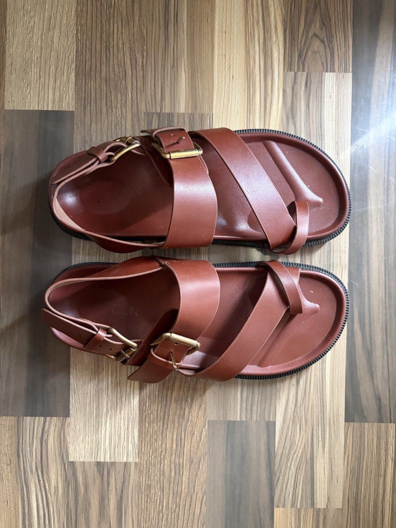 CLN Brown Buckle Sandals (Category: Flats & Sandals) located in Los Banos. Submitted by _bugsssbunny (Listing ID 1468726375, Image 3). Description: - Brand/Style: CLN leather sandals in a rich brown earthy neutral shade - Design: Cross-strap toe loop with adjustable metal pin buckles - Comfort & Sole: Contoured footbed and durable structured lug sole - Condition: Minimal wear visible on the straps and footbed.