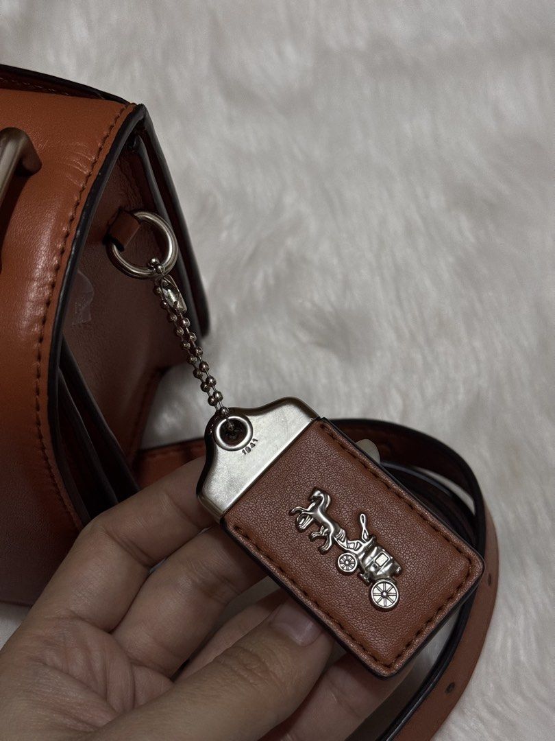 Coach Brown Leather Crossbody Bag (Category: Cross-body Bags) located in Mexico. Submitted by alexacarts (Listing ID 1468850700, Image 2). Description: - Brand: Coach - Style: Crossbody bag - Material: Rich brown leather with full grain leather interior lining - Hardware: Silver-tone with signature C front clasp - Details: Includes matching leather hangtag with horse and carriage emblem - Strap: Adjustable shoulder strap - Compartments: Divided i