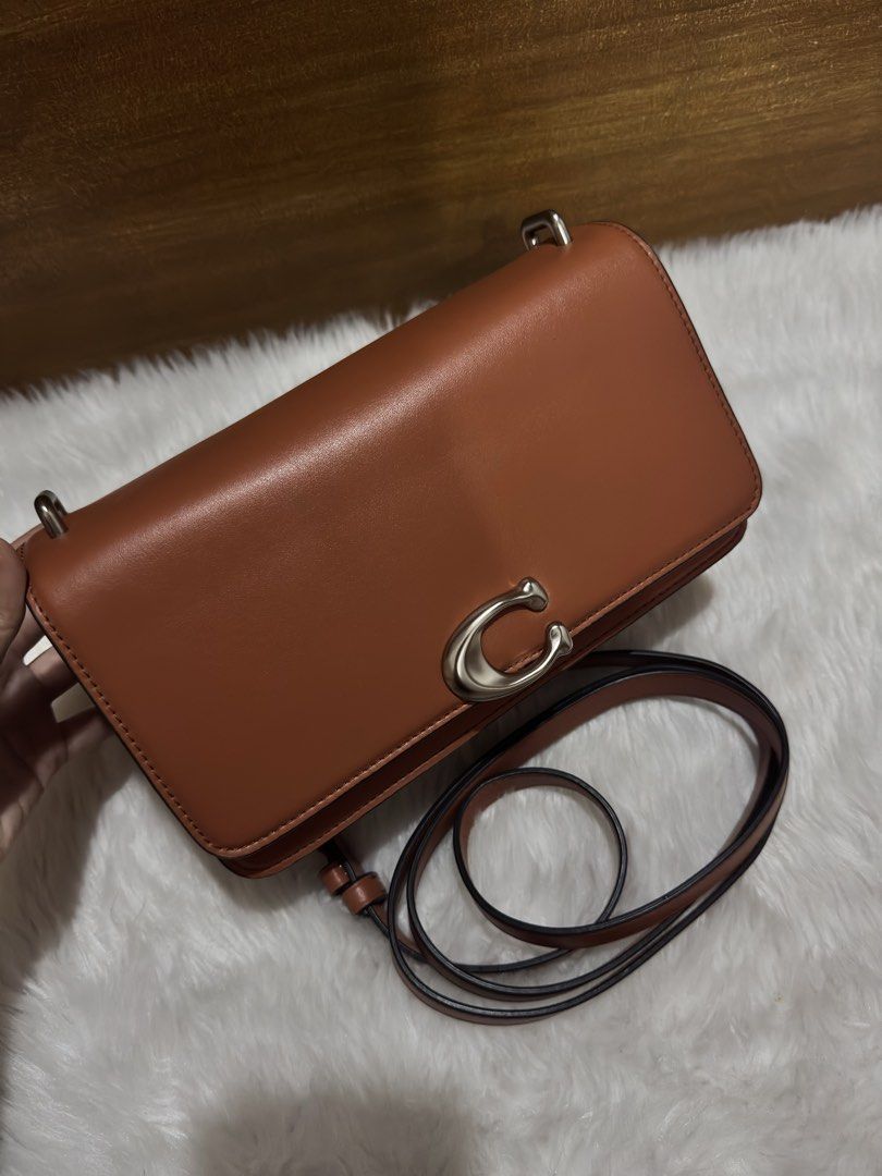 Coach Brown Leather Crossbody Bag (Category: Cross-body Bags) located in Mexico. Submitted by alexacarts (Listing ID 1468850700, Image 1). Description: - Brand: Coach - Style: Crossbody bag - Material: Rich brown leather with full grain leather interior lining - Hardware: Silver-tone with signature C front clasp - Details: Includes matching leather hangtag with horse and carriage emblem - Strap: Adjustable shoulder strap - Compartments: Divided i