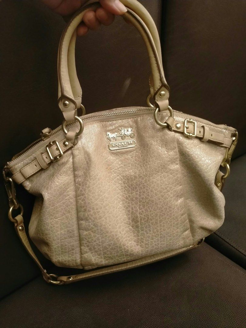 Coach Metallic Beige Leather Satchel Strap (Category: Luxury Bags & Wallets) located in Pasig City. Submitted by cool.itshara (Listing ID 1468783840, Image 2). Description: - Brand: Coach - Color: Metallic Beige - Style: Structured satchel bag with top handles and detachable shoulder strap - Hardware: Gold-tone with stylish side buckle accents - Branding: Iconic Coach horse and carriage front logo plaque - Closure: Secure top zipper closure - Int
