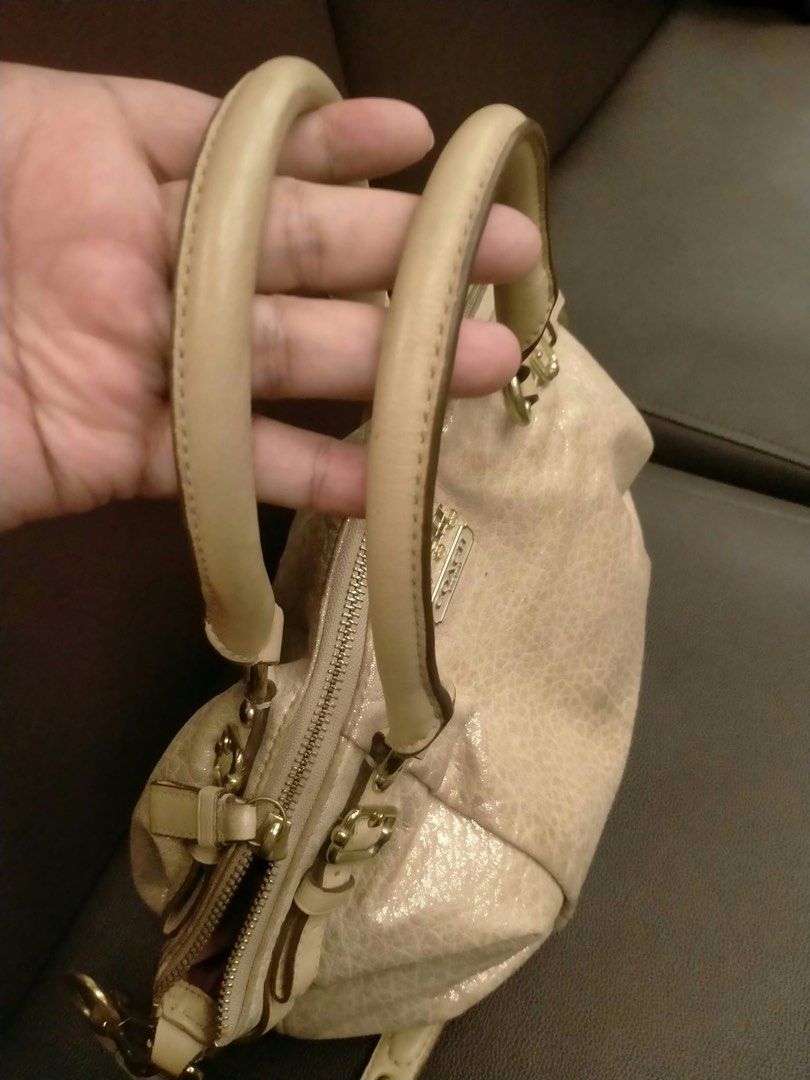 Coach Metallic Beige Leather Satchel Strap (Category: Luxury Bags & Wallets) located in Pasig City. Submitted by cool.itshara (Listing ID 1468783840, Image 3). Description: - Brand: Coach - Color: Metallic Beige - Style: Structured satchel bag with top handles and detachable shoulder strap - Hardware: Gold-tone with stylish side buckle accents - Branding: Iconic Coach horse and carriage front logo plaque - Closure: Secure top zipper closure - Int