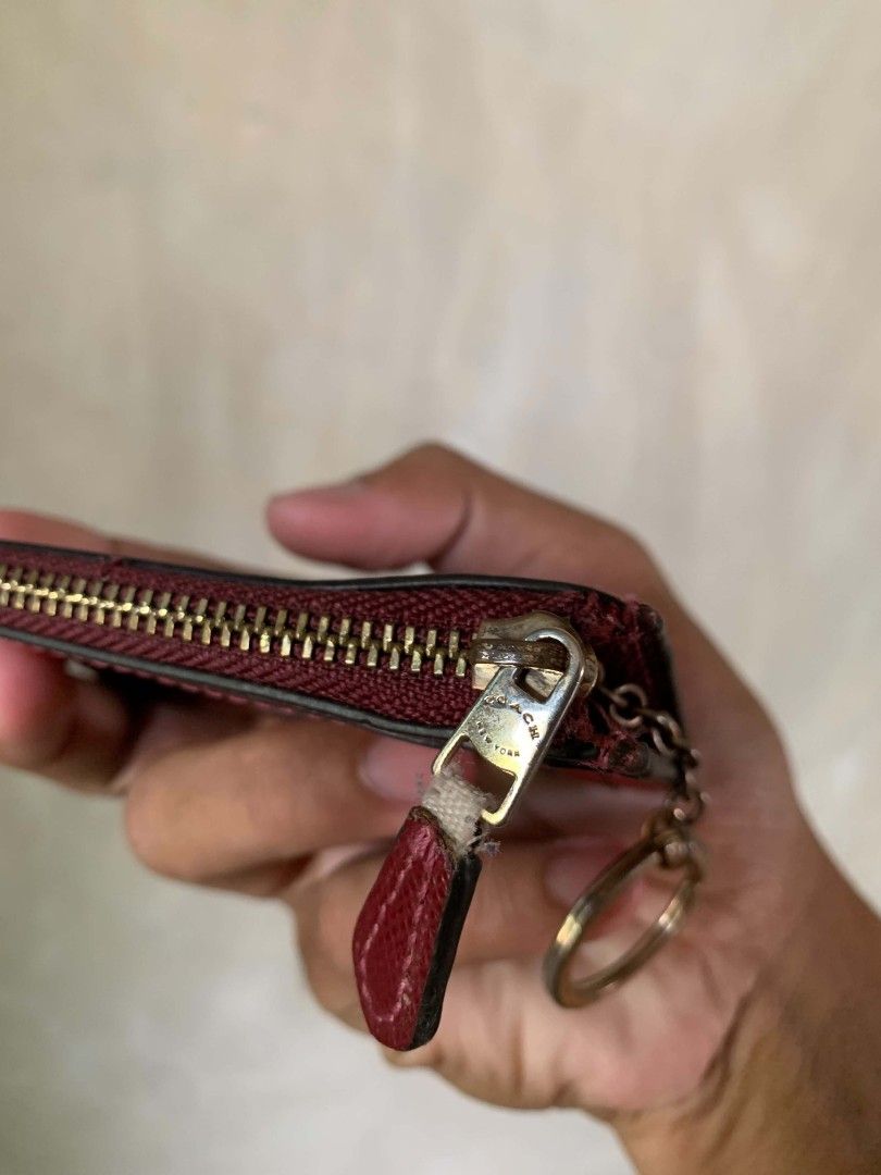 Coach Red Leather Zip Card Case Pouch (Category: Wallets & Card holders) located in Bula. Submitted by wenceslao_aiu (Listing ID 1468788098, Image 2). Description: - Brand: Coach - Material: Red pebbled leather with gold-tone hardware - Style Number: F1878 - Features: Zip closure, attached key ring, and inside chain - Interior: Fabric lining, stamped 'Made in Philippines' - Size: Compact for daily essentials, cards, and keys - Condition: Minor we