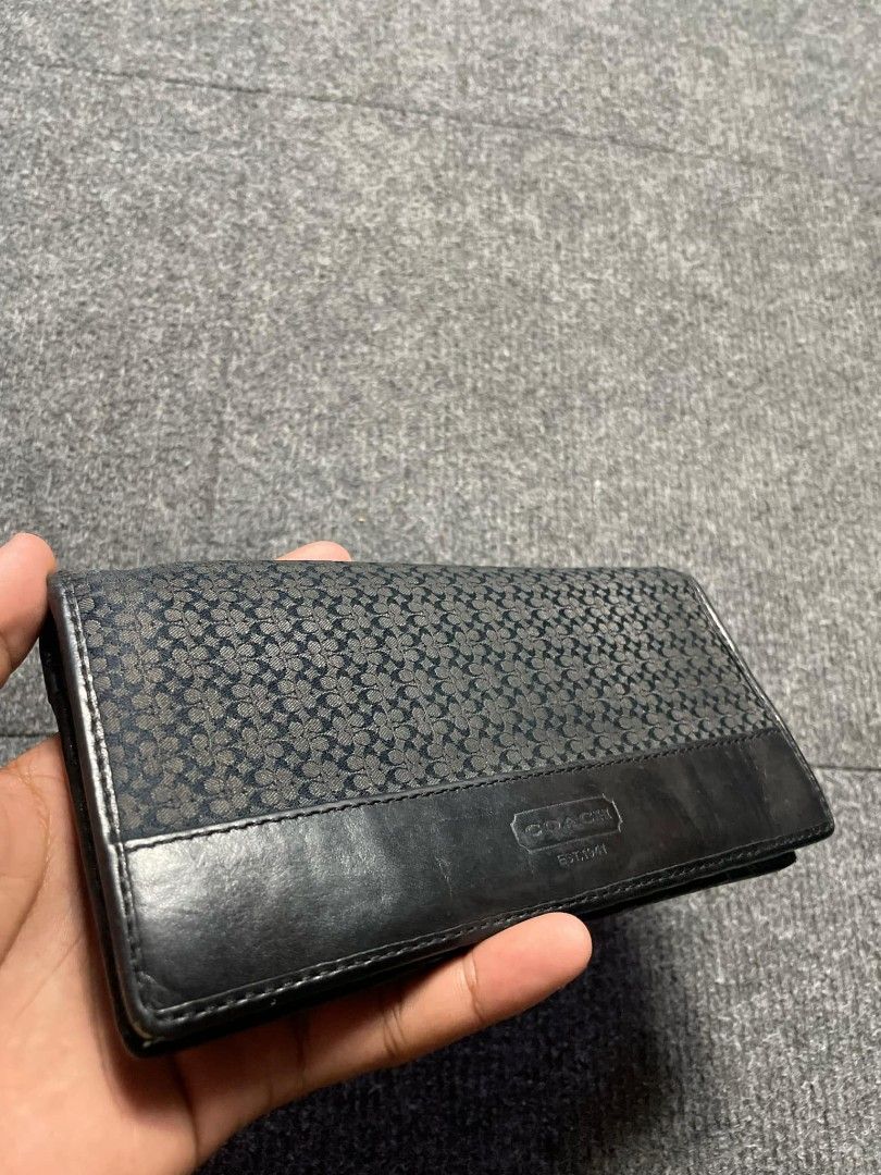 Coach Signature Black Long Wallet (Category: Wallets & Card holders) located in Ligao. Submitted by merjudioma64633 (Listing ID 1468748159, Image 3). Description: - Authentic Black Coach Long Wallet - Material: Signature patterned canvas and leather - Closure: Flap with debossed Coach logo plate - Interior: Multiple card slots, slip compartments, and a secure zippered pocket - Condition: Shows minor signs of wear on inner lining edges and zip pul