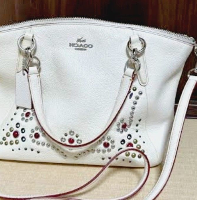 Coach White Leather Studded Handbag with Shoulder Strap (Category: Cross-body Bags) located in Manila. Submitted by lene48 (Listing ID 1468776194, Image 1). Description: - Brand: Coach - Color: White with colorful studs and metallic embellishments - Material: Premium pebbled leather - Hardware: Silver-tone - Closure: Secure top zipper - Carry Options: Dual top handles and a detachable matching shoulder strap - Includes: Original leather hangtag.