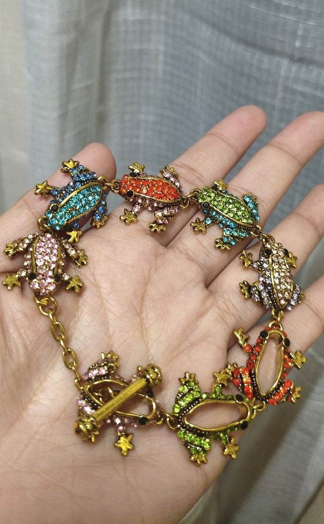 Colorful Rhinestone Frog Chain Bracelet (Category: Bracelets) located in Quezon City. Submitted by gemaicloset (Listing ID 1468865122, Image 1). Description: - Fun and whimsical frog chain bracelet - Covered in colorful rhinestones featuring blue, orange, green, pink, and purple jewel tones - Gold-tone metal link chain with secure toggle clasp closure - Standard bracelet length - Unbranded costume jewelry - Perfect statement piece for animal love