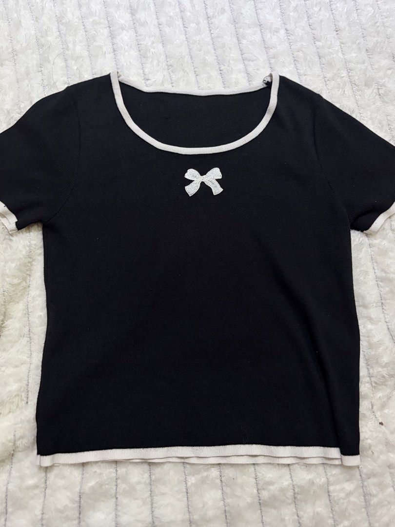 Coquette Contrast-Trim Baby Tee (Category: Sleeveless) located in San Mateo. Submitted by heiayafinds (Listing ID 1468834127, Image 1). Description: - Color: Classic black with white trim on the neckline, cuffs, and hem - Design: Features a sweet small white bow applique right below the scoop collar - Fit: Slim fit through the torso with a flattering silhouette - Material: Soft, stretchy knit fabric for all-day comfort - Styling: Easily pairs wit