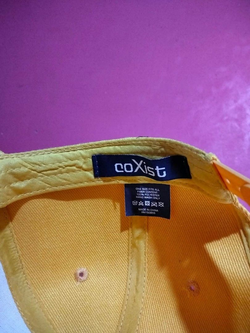 CoXist Yellow Snapback Cap (Category: Caps & Hats) located in Mangaldan. Submitted by niftythrifty69 (Listing ID 1468729661, Image 3). Description: - Brand: CoXist - Color: Solid yellow - Style: Classic snapback with flat brim and adjustable fit - Material: 100% polyester - Size: One size fits all - Care: Hand wash only.
