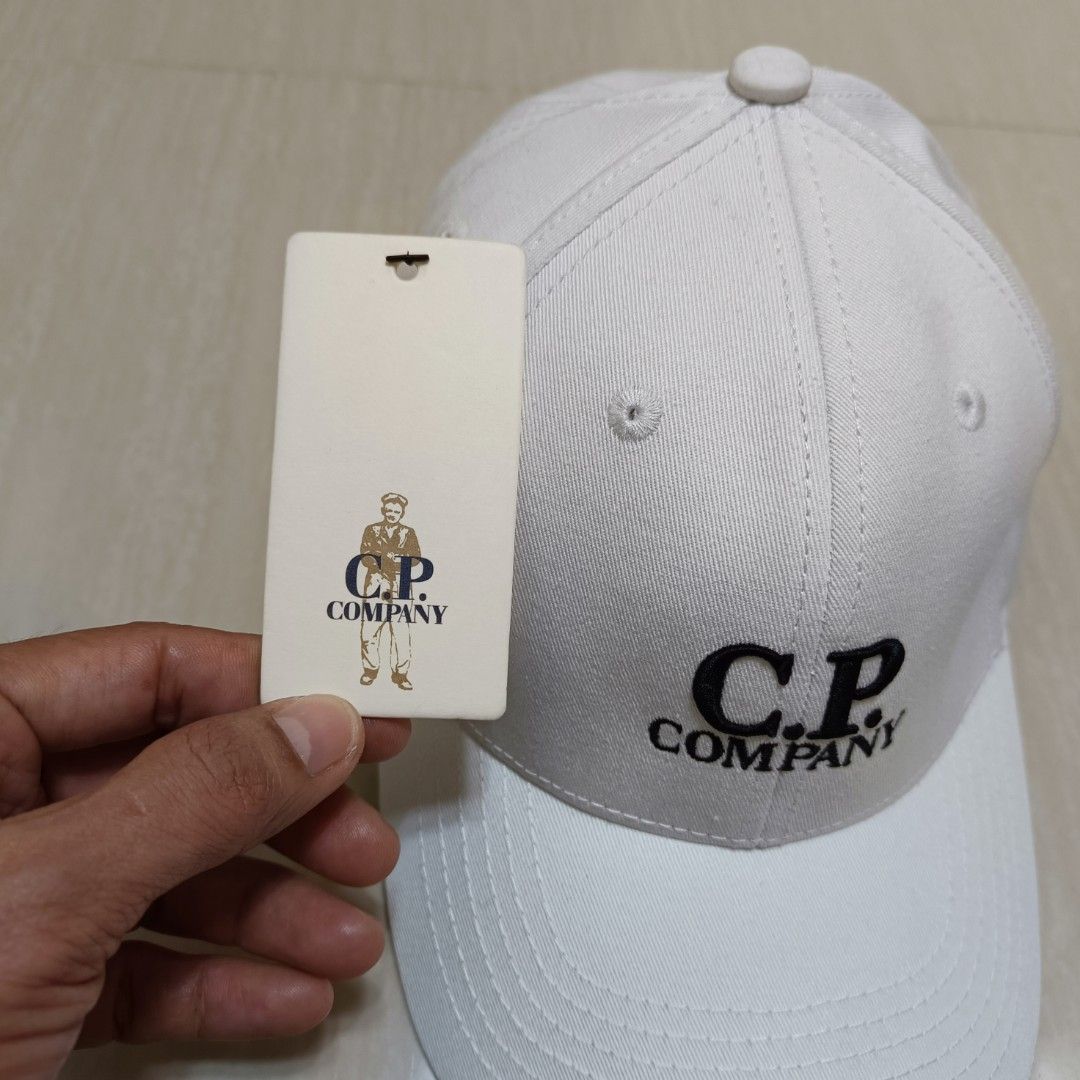C.P. Company Cap Embroidery Adjustable Back (Category: Caps & Hats) located in Nasugbu. Submitted by staffpicks1515 (Listing ID 1468793627, Image 3). Description: - Brand: C.P. Company - Color: White - Details: Embroidered black logo on front and matching embroidery on back - Hardware: Adjustable strap with metal buckle (embossed branding) - Interior: Branded taping and tags - Condition: Brand new with original hangtag attached.