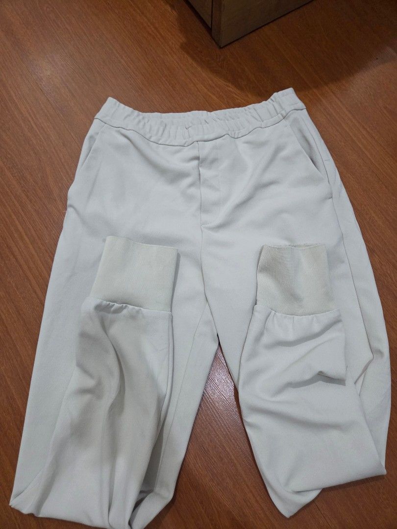 Cream beige jogger pants with elastic cuffs and drawstring (Category: Other Bottoms) located in Taguig. Submitted by mon_143 (Listing ID 1468901800, Image 1). Description: - Color: Cream beige - Material: Nice, soft fabric - Waistband: Elastic with adjustable drawstring - Cuffs: Ribbed with stylish split hems - Pockets: Two welt pockets on the back - Condition: Good, but has a dark ink stain near the bottom hem (please check photos closely).
