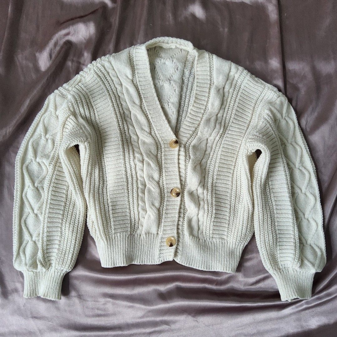 Cream Cable Knit V-Neck Button Cardigan (Category: Coats, Jackets and Outerwear) located in Quezon City. Submitted by freedolphin_bb6035 (Listing ID 1468781612, Image 2). Description: - Color: Creamy white - Material: Thick cable knit - Design: V-neck with three large tortoiseshell-style buttons - Sleeves: Long puff sleeves with ribbed cuffs and hem - Fit: Cropped and cozy - Condition: Worn once, freshly washed and properly stored.