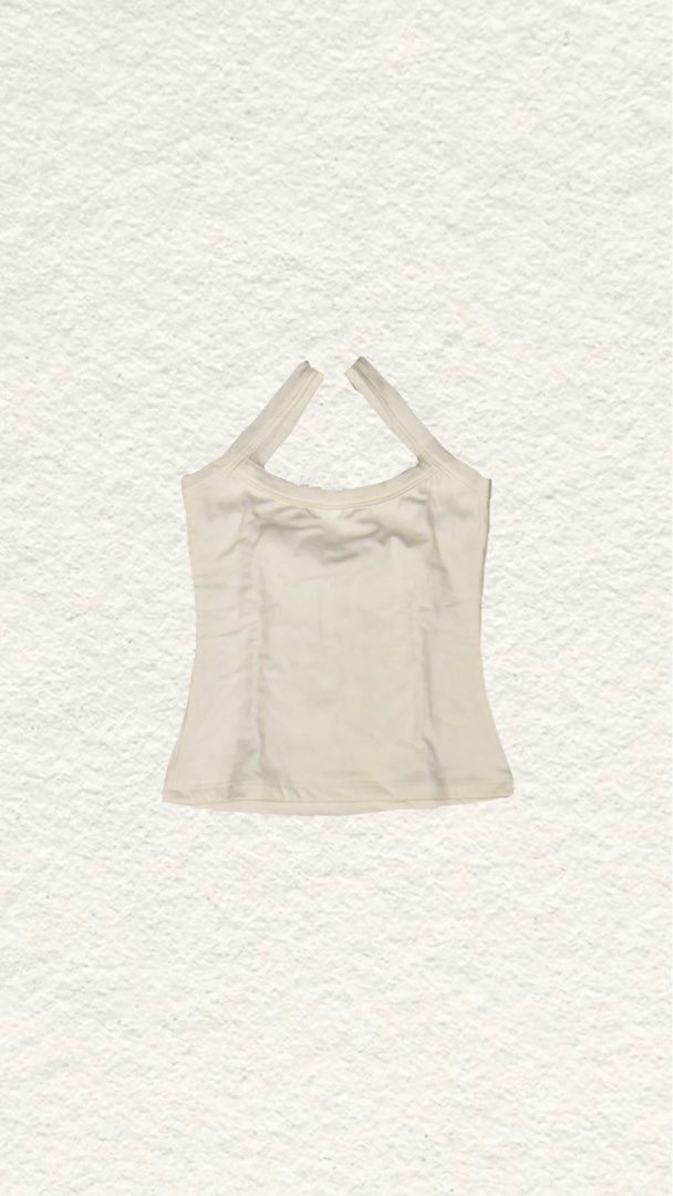 Cream Halter Neck Tank Top (Category: Sleeveless) located in Quezon City. Submitted by zealhorse_a9f3c3 (Listing ID 1468798113, Image 1). Description: - Color: Cream - Style: Halter tank top with scoop neckline and thick criss-cross straps - Fit: Fitted silhouette with a clean finish hem - Material: Soft and stretchy - Versatility: Great for casual daily wear or easy layering.