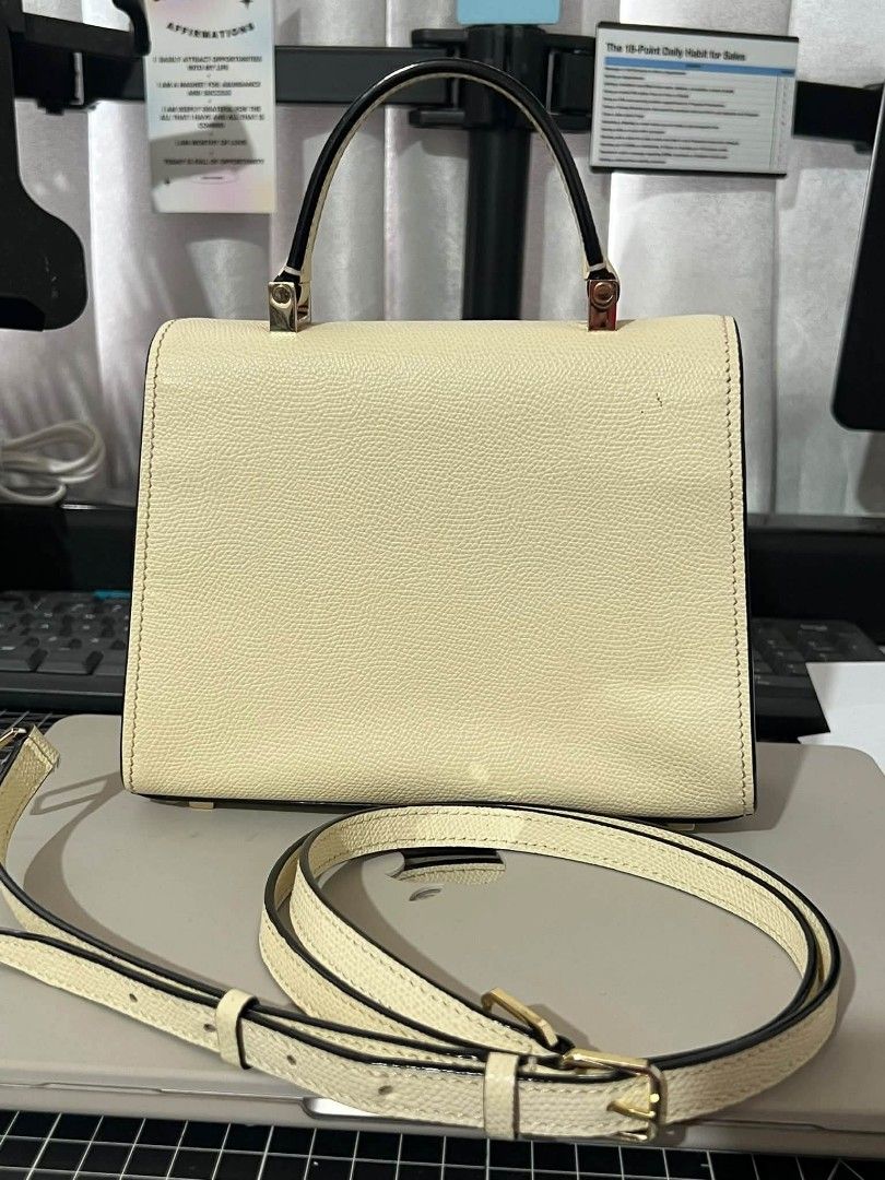 Cream Top Handle Bag with Shoulder Strap (Category: Luxury Bags & Wallets) located in Manila. Submitted by boldfire_315559 (Listing ID 1468798527, Image 3). Description: - Color/Finish: Cream structured textured leather with contrasting black trim - Hardware: Premium gold-toned hardware with a secure front flap closure and rectangular metal clasp - Versatility: Includes a single top handle and a removable, adjustable matching shoulder strap - Pro