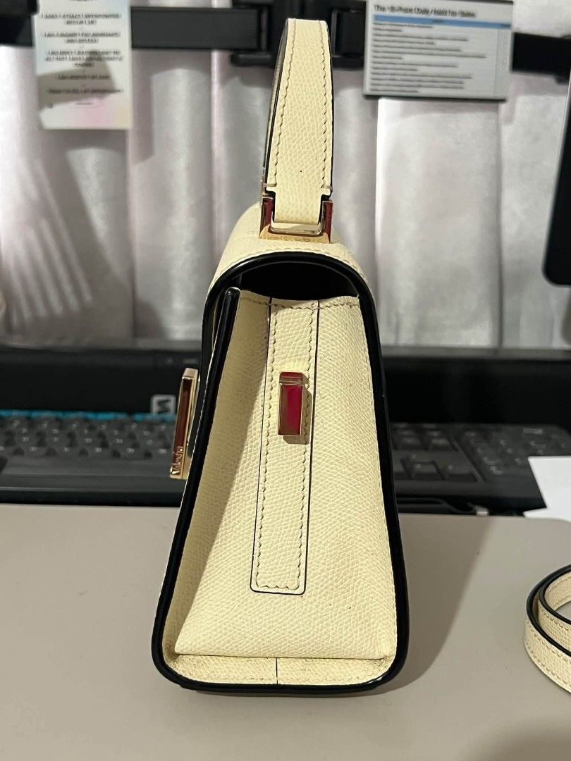 Cream Top Handle Bag with Shoulder Strap (Category: Luxury Bags & Wallets) located in Manila. Submitted by boldfire_315559 (Listing ID 1468798527, Image 2). Description: - Color/Finish: Cream structured textured leather with contrasting black trim - Hardware: Premium gold-toned hardware with a secure front flap closure and rectangular metal clasp - Versatility: Includes a single top handle and a removable, adjustable matching shoulder strap - Pro