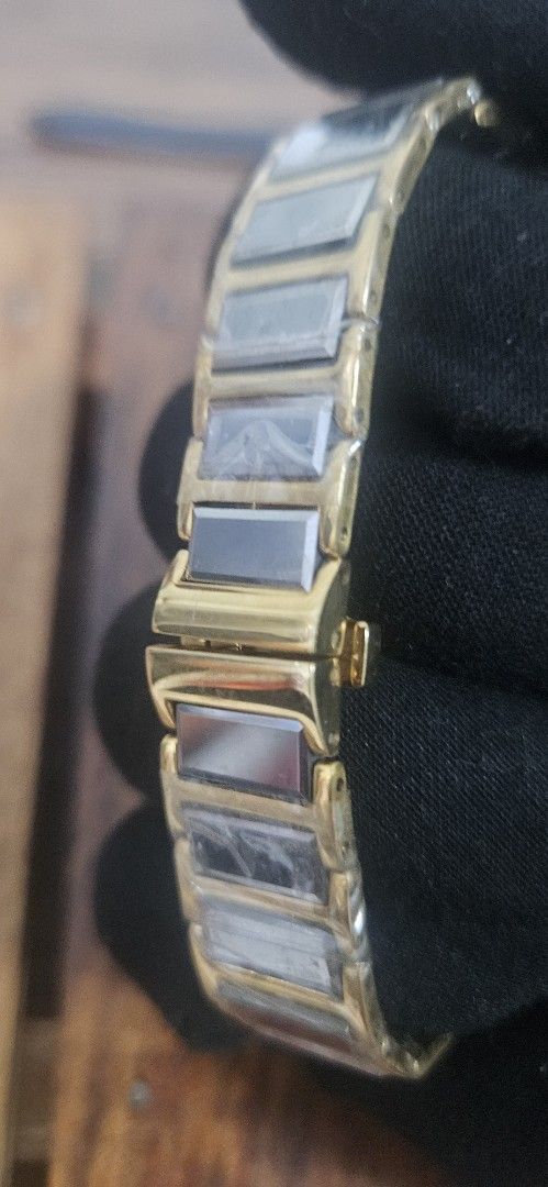 Crocodile International gold tone rectangle watch (Category: Women's Watches) located in Santa Maria. Submitted by rommelmateo (Listing ID 1468859619, Image 3). Description: - Brand: Crocodile International - Style: Gold-tone watch with a sleek rectangular dark dial and gold hands - Case: Gold case with elegant curved sides - Strap: Bracelet strap with alternating links, still wrapped in original protective plastic - Closure: Secure fold-over cla