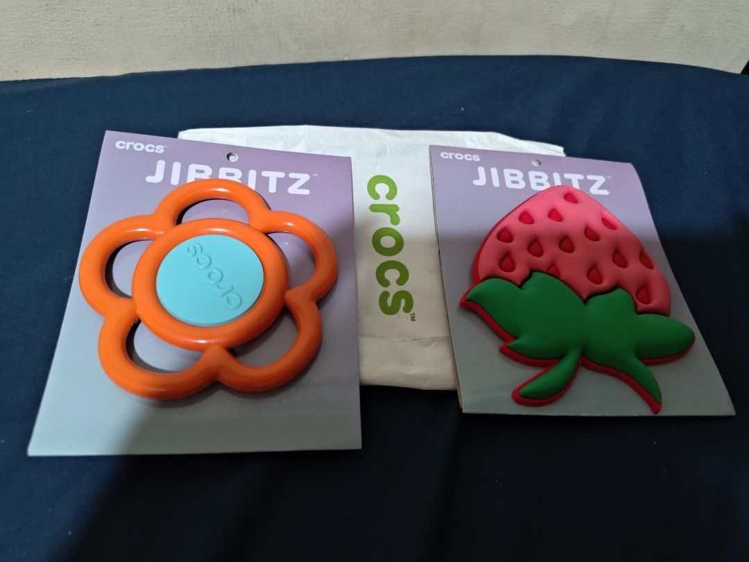 Crocs Jibbitz Mega Orange and Blue Flower & Mega Strawberry (Category: Slippers and slides) located in Valenzuela. Submitted by wisewhale_46982b (Listing ID 1468773209, Image 1). Description: - Official Crocs merchandise: Authentic Jibbitz charms - Set of 2 oversized designs: Mega blue/orange flower and mega pink/green strawberry - Brand new: Still attached to original purple packaging - Versatile: Great way to personalize and customize Crocs clo