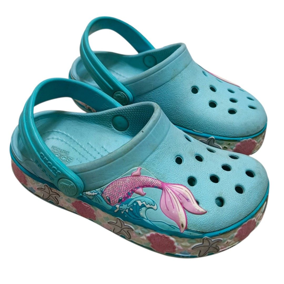 Crocs Kids Mermaid Clogs Size 8 Turquoise (Category: Babies & Kids Fashion) located in Nasugbu. Submitted by staffpicks1515 (Listing ID 1468792240, Image 3). Description: - Brand/Item: Kids' Crocs Clogs - Size: 8 - Color: Turquoise - Design: Fun mermaid tail on the side with seashell and starfish graphics - Condition: Normal signs of wear (only washable dirt) - Features: Easy slip-on design, perfect for everyday play.