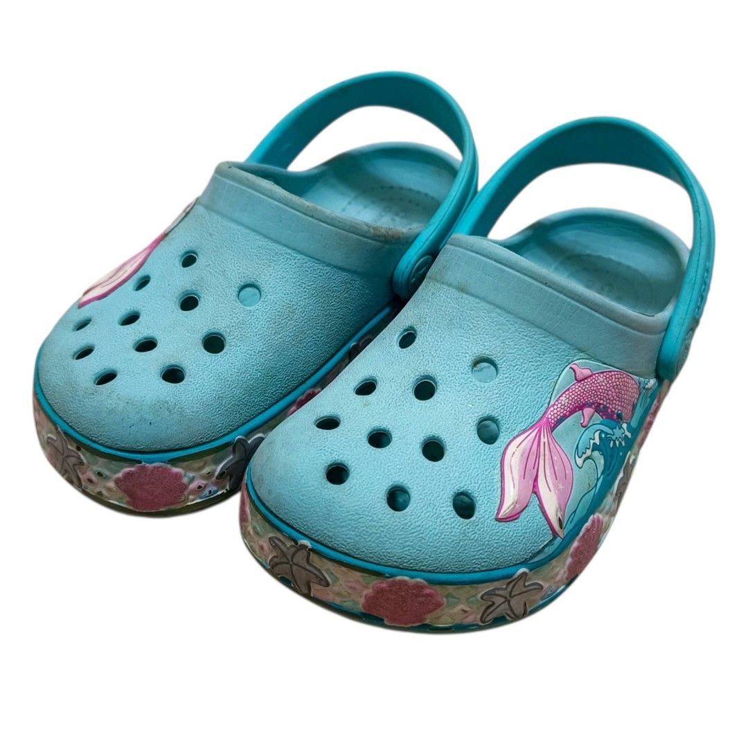 Crocs Kids Mermaid Clogs Size 8 Turquoise (Category: Babies & Kids Fashion) located in Nasugbu. Submitted by staffpicks1515 (Listing ID 1468792240, Image 2). Description: - Brand/Item: Kids' Crocs Clogs - Size: 8 - Color: Turquoise - Design: Fun mermaid tail on the side with seashell and starfish graphics - Condition: Normal signs of wear (only washable dirt) - Features: Easy slip-on design, perfect for everyday play.