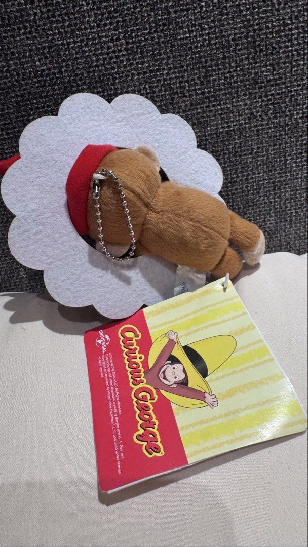Curious George Christmas Wreath Plush Keychain (Category: Plushies & Soft Toys) located in Mandaluyong City. Submitted by maelovestoshop (Listing ID 1468873195, Image 2). Description: - Authentic Universal Studios merchandise - Curious George plush toy wearing a festive red elf hat - Cute felt Christmas wreath frame design - Equipped with a ball chain for easy hanging on bags or keys - Comes with original paper hang tag attached - Great gift idea