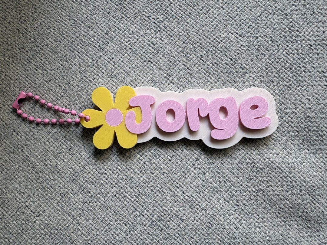 Custom 3D Printed Flower Name Keychain (Category: Handmade Craft) located in Paranaque City. Submitted by sqt_closet (Listing ID 1468736115, Image 1). Description: - Custom name keychain - White base with playful pink bubble letters - Adorned with a yellow flower (pink center) on the left side 1pc for P45 each 5pcs for 210 10pcs 400.