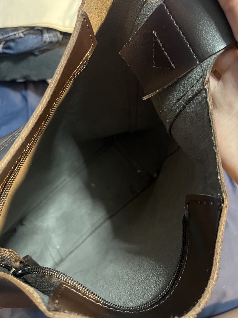 Dark Brown Leather Bucket Shoulder Bag (Category: Shoulder Bags) located in Marikina City. Submitted by yssacee (Listing ID 1468914801, Image 3). Description: - Color & Material: Dark brown faux leather with silver-tone buckle - Closure & Interior: Secure zippered top with a spacious, unlined raw interior - Strap: Adjustable for a customized fit - Style: Minimalist design, ideal for everyday use - Condition: Brand new with minor dust specs from s