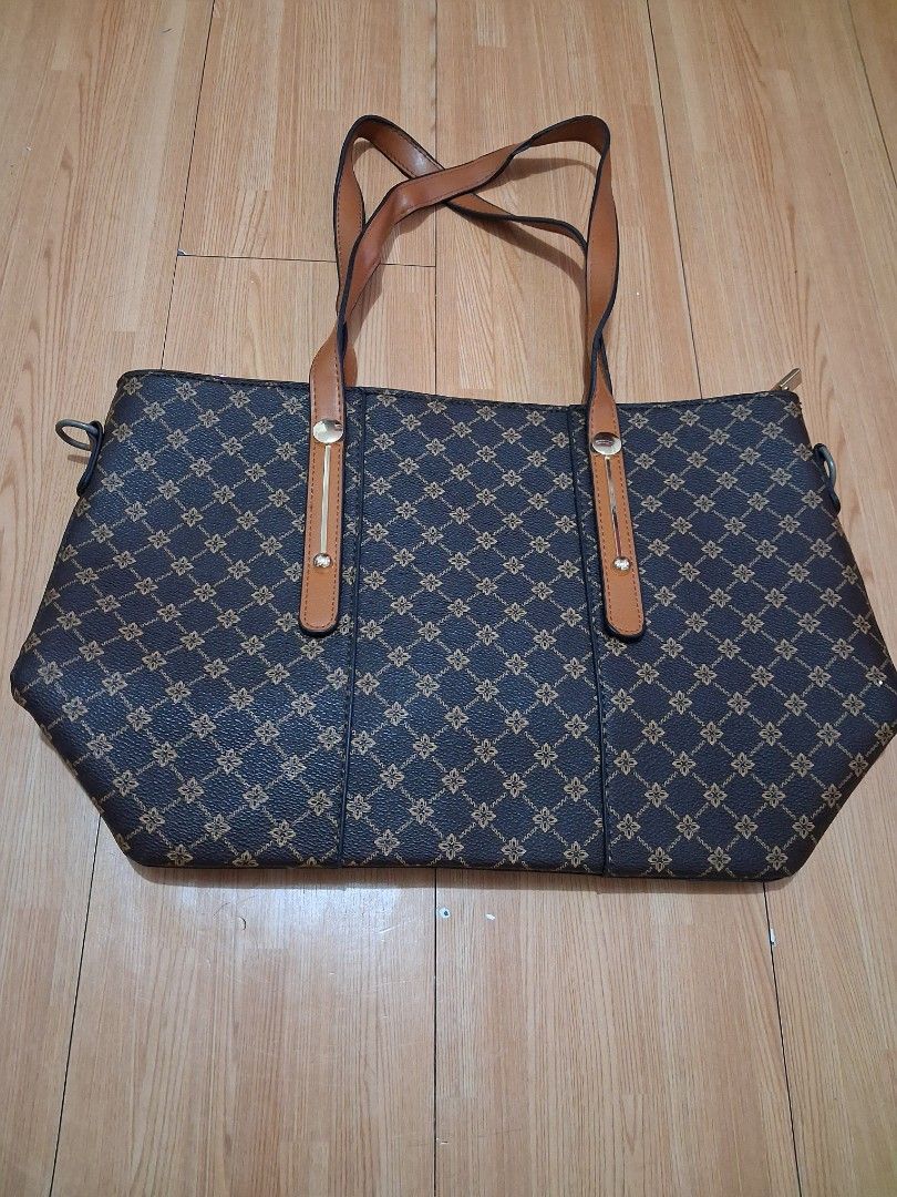 Dark brown tote bag with geometric print and tan straps (Category: Tote Bags) located in Quezon City. Submitted by lydia1127 (Listing ID 1468929607, Image 2). Description: - Dark brown tote bag with stylish repeating geometric pattern - Contrast tan straps secured with elegant gold-tone hardware - Secure top zipper closure to keep your belongings safe - Spacious interior with plenty of room for daily essentials.