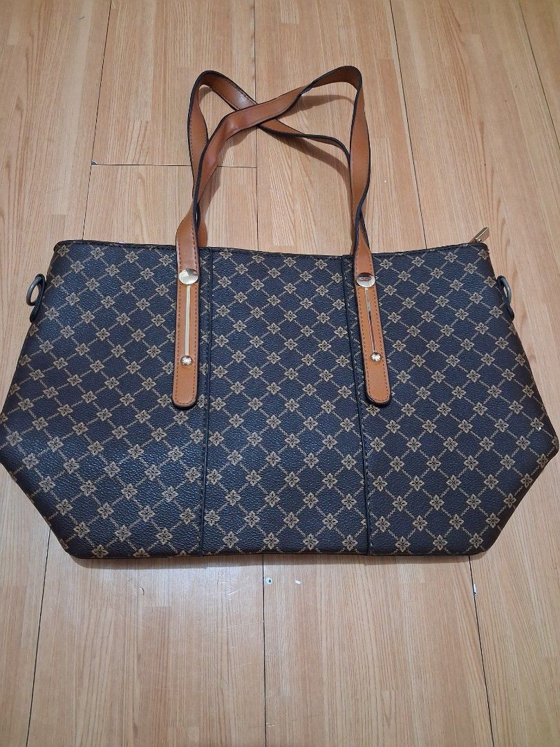 Dark brown tote bag with geometric print and tan straps (Category: Tote Bags) located in Quezon City. Submitted by lydia1127 (Listing ID 1468929607, Image 1). Description: - Dark brown tote bag with stylish repeating geometric pattern - Contrast tan straps secured with elegant gold-tone hardware - Secure top zipper closure to keep your belongings safe - Spacious interior with plenty of room for daily essentials.