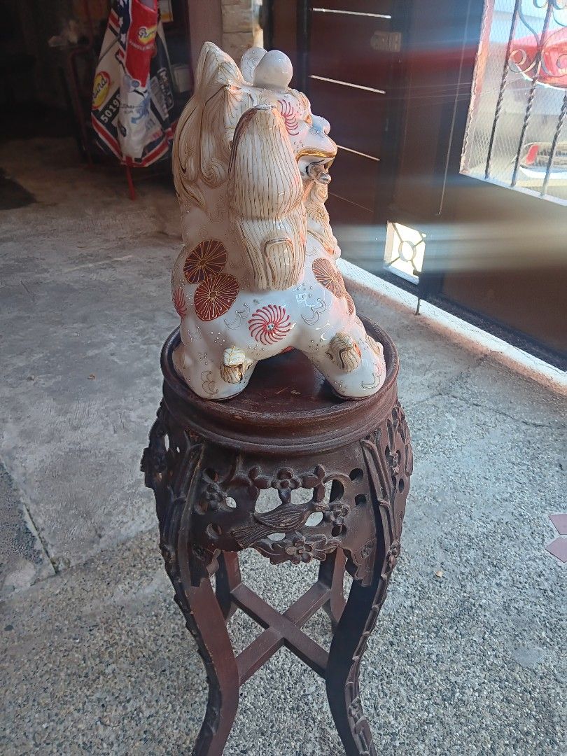 Decorative Ceramic Foo Dog Statue with Stand (Category: Figurines & Statues) located in Las Pinas. Submitted by jesus1smysavi0r (Listing ID 1468738800, Image 3). Description: - Type: Traditional Asian ceramic foo dog decor - Design: Foo dog holding a sword, perched on an ornate ball - Details: Hand-painted in blue, red, gold, and turquoise with raised gold linework on the tail and mane - Stand: Includes a carved dark wood tall display stand with 