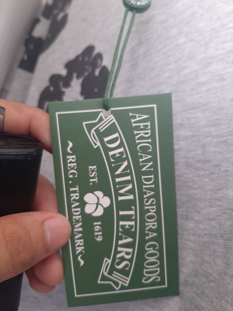 Denim tears (Category: Formal Shirts) located in Caloocan City. Submitted by oddriver_c0926d (Listing ID 1468751493, Image 3). Description: Heather grey oversized cotton fabric, complete with its original green brand tag attached near the crewneck collar.