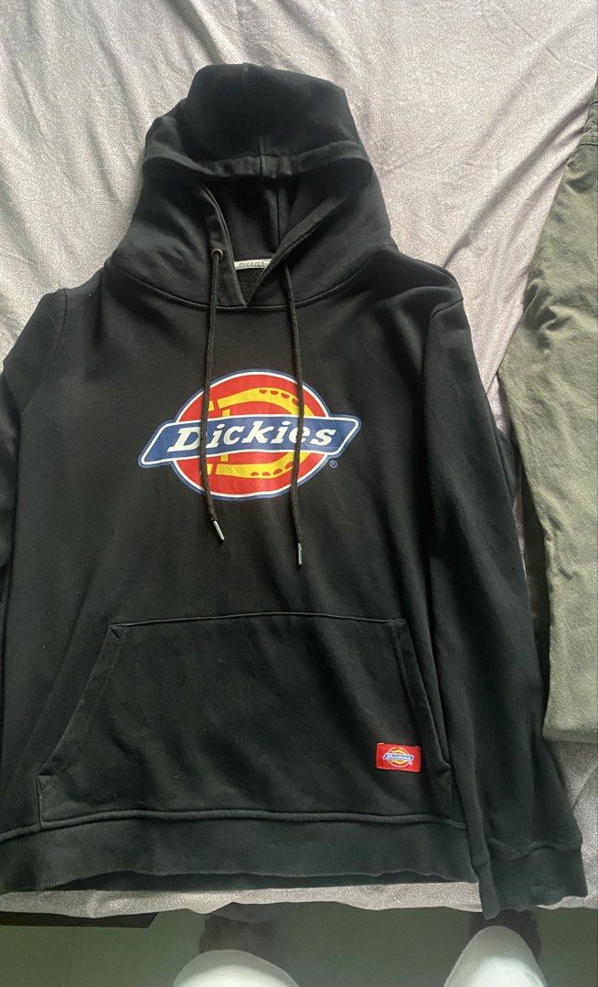 Dickies Black Hoodie with Front Logo (Category: Hoodies) located in Vinzons. Submitted by gabrielvic (Listing ID 1468741204, Image 1). Description: - Brand: Dickies - Color: Black with multicolored horseshoe logo on chest - Material: 100% cotton with soft fleece interior lining - Features: Drawstring hood, front kangaroo pocket, and small red Dickies logo tag - Fit: Standard fit, ideal for daily casual wear - Condition: Excellent / Ready to wear.
