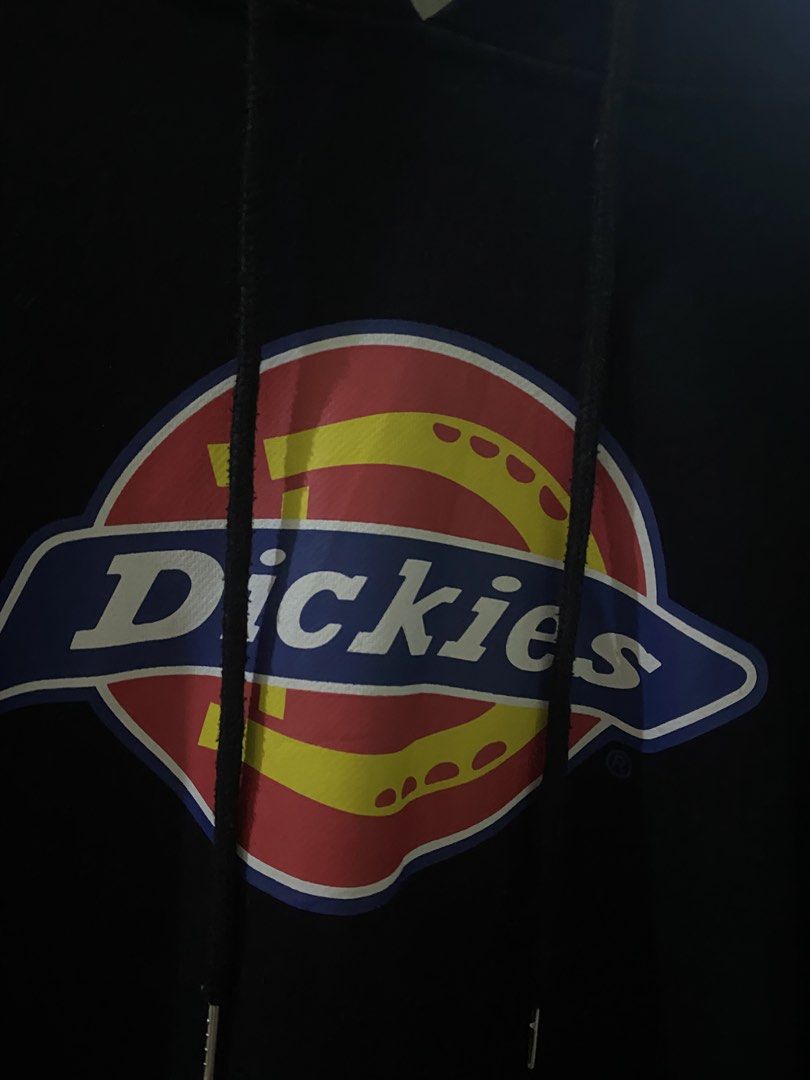 Dickies Black Hoodie with Front Logo (Category: Hoodies) located in Vinzons. Submitted by gabrielvic (Listing ID 1468741204, Image 2). Description: - Brand: Dickies - Color: Black with multicolored horseshoe logo on chest - Material: 100% cotton with soft fleece interior lining - Features: Drawstring hood, front kangaroo pocket, and small red Dickies logo tag - Fit: Standard fit, ideal for daily casual wear - Condition: Excellent / Ready to wear.