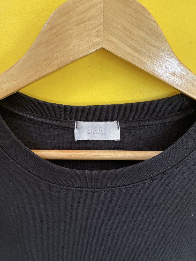 Dior Black Graphic T-Shirt (Category: Tshirts & Polo Shirts ) located in Baguio. Submitted by yuno.cartel (Listing ID 1468728425, Image 3). Description: - Brand: Dior - Color: Black with grey and white graphic print - Size: Medium (M) - Material: 100% viscose - Design: Unique graphic wrapping from front chest to back right hem - Fit: Crew neck with standard short sleeves -large fit boxy.